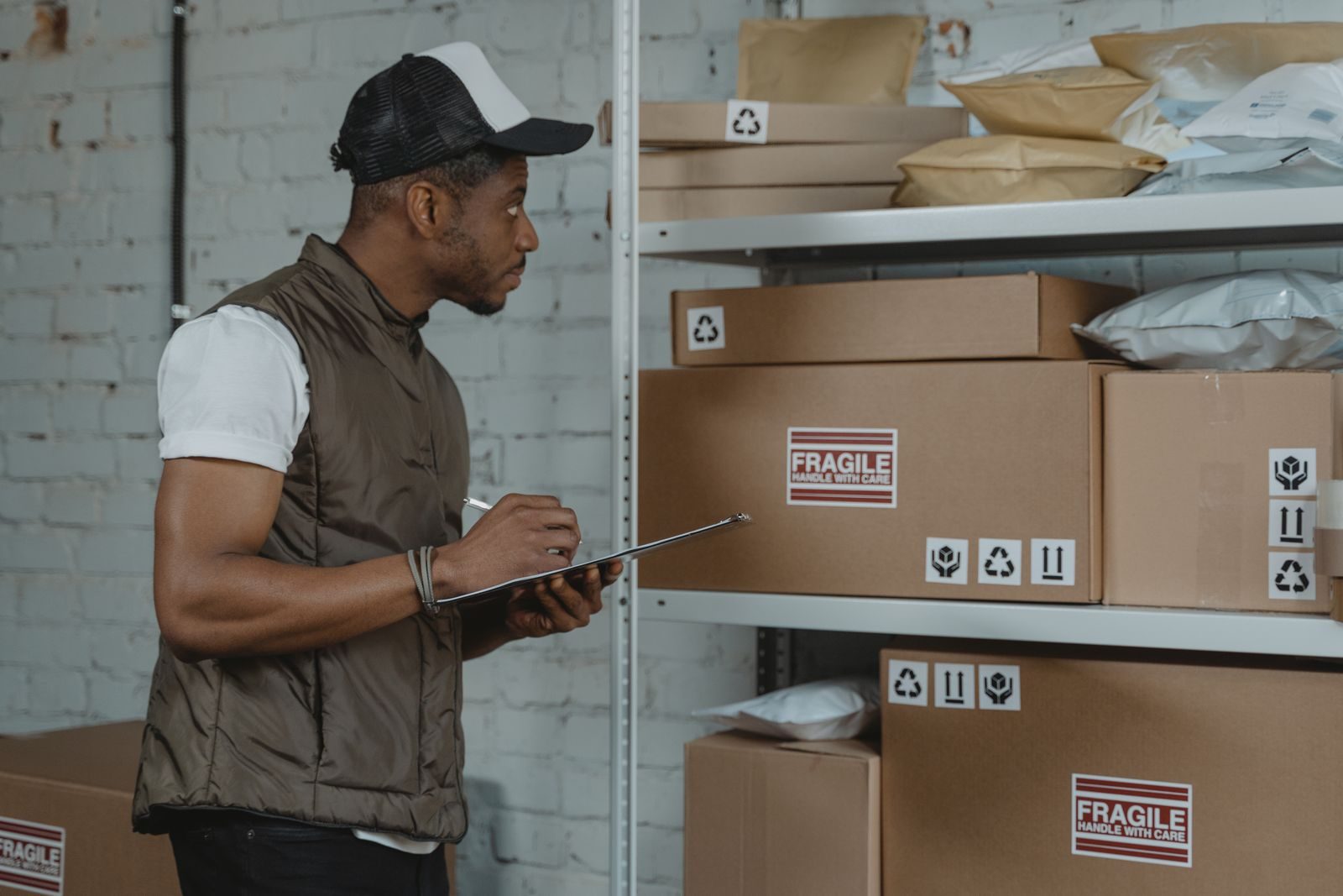 A warehouse worker checking goods against paperwork.