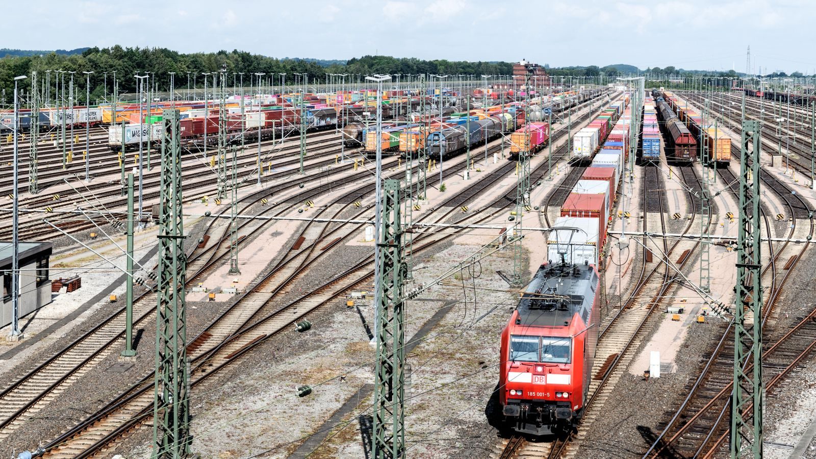 A railway container yard with multiple tracks and trains.